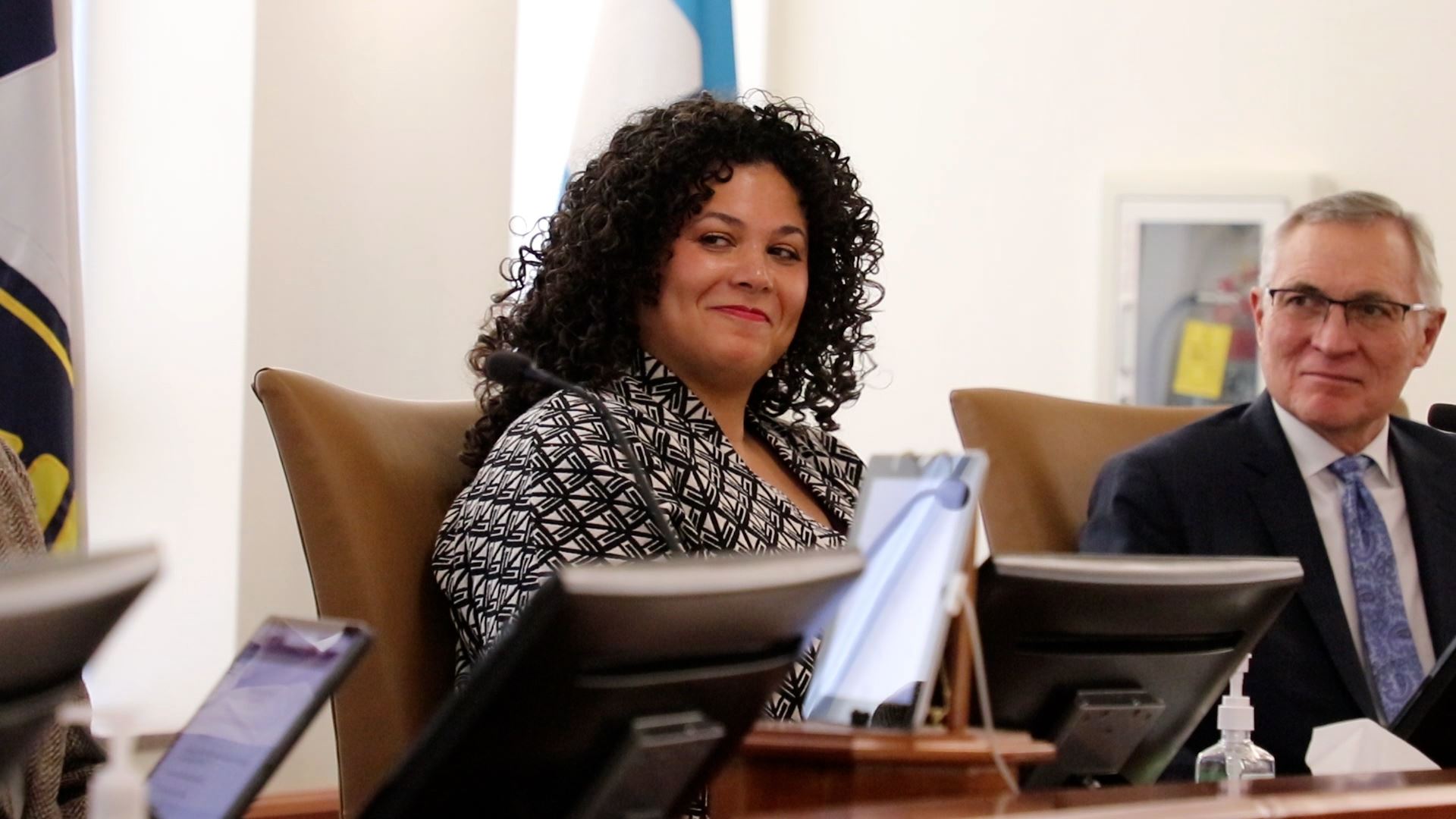Alicia Washington smiles while seated at the dais